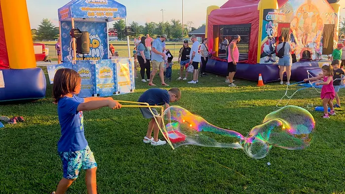 Kids chasing giant bubbles at a bubble party
