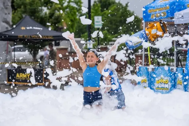A child leaping through a pile of foam at a Wild Foam Adventures party