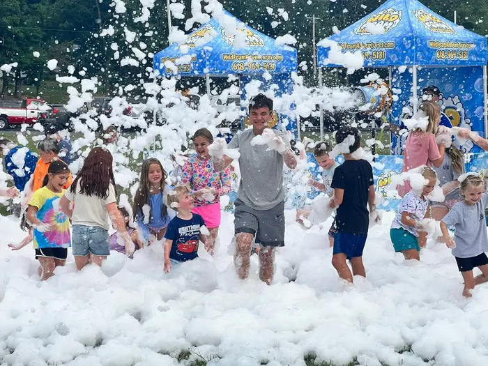 Kids running through a mountain of foam