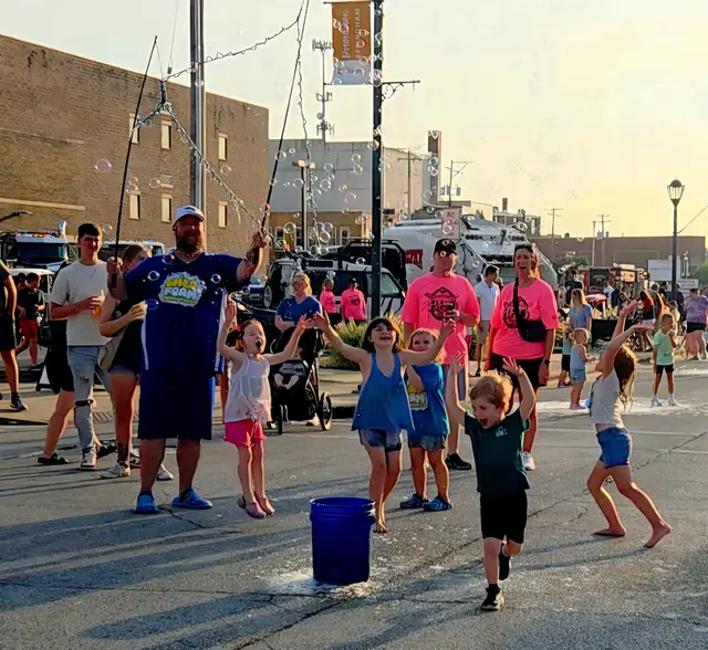 Children popping giant bubbles